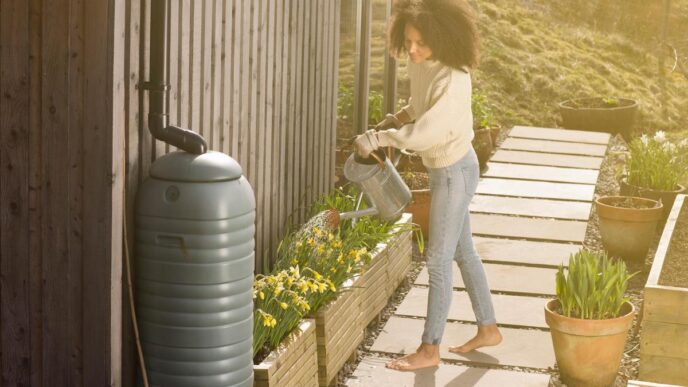 Rainwater harvesting system in a vibrant garden with flowers and sunlight.